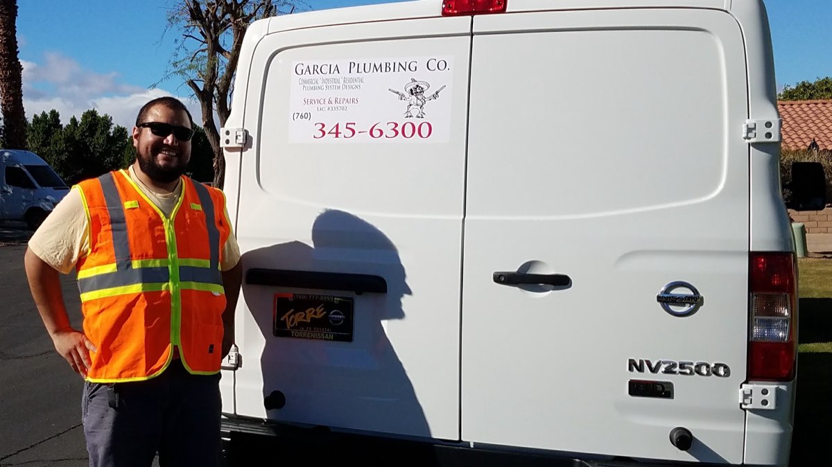 Garcia Plumbing Company owner with the company service van